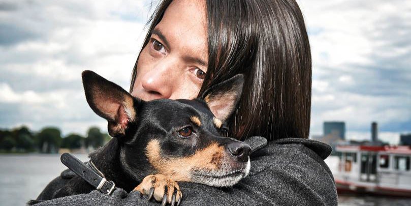 Jorge Gonzalez umarmt seinen Hund, der seinen Kopf auf Jorges Schultern legt