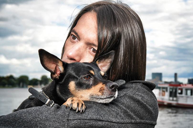 Jorge Gonzalez umarmt seinen Hund, der seinen Kopf auf Jorges Schultern legt